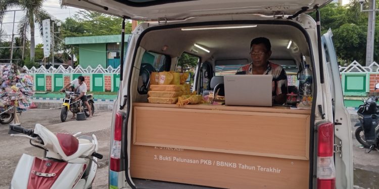 📷 Abdul Haris Bros dan tumpukan hadiah menarik dari kantor Samsat Dompu di gerbang timur Masjid Raya Dompu. (my).