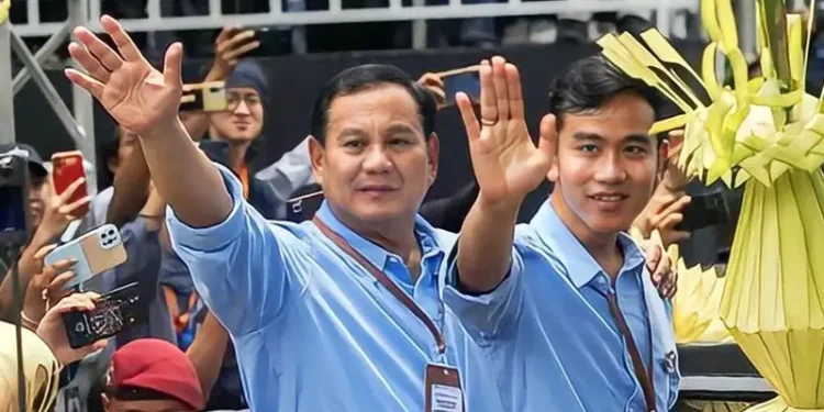 📷 Bersama Prabowo, Gibran tampil mengenakan kemeja warna biru muda lengan panjang. Tampak ia bersama Prabowo mengenakan lanyard coklatnya. (Liputan6.com).