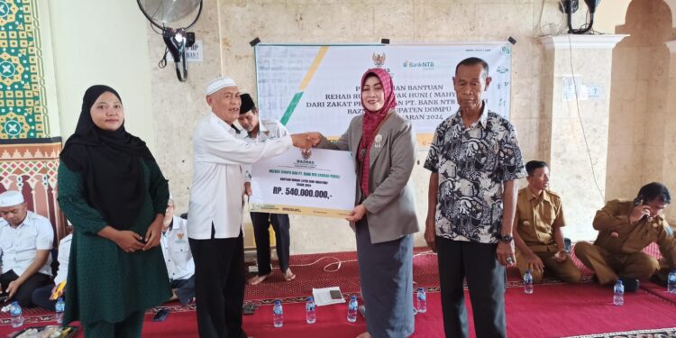 📷 Kepala Bank NTB Syariah Cabang Dompu menyerahkan secara simbolik bantuan Mahyani kepada Baznas Kabupaten Dompu sebelum diberikan kepada penerima manfaat. (Mf).